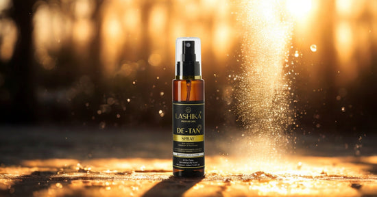 A bottle of Lashika De-Tan Spray stands upright on a sunlit surface with golden light and misty water droplets surrounding it. The background features a warm, glowing bokeh effect of sunlight streaming through trees, creating a radiant and fresh ambiance