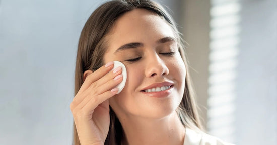 A woman applying toner on her face with cotton and feeling hydrated with that misty fresh glow