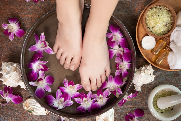 A serene image of a woman's feet adorned with flowers next to a bowl of water, emphasizing Lashika footcare advice.