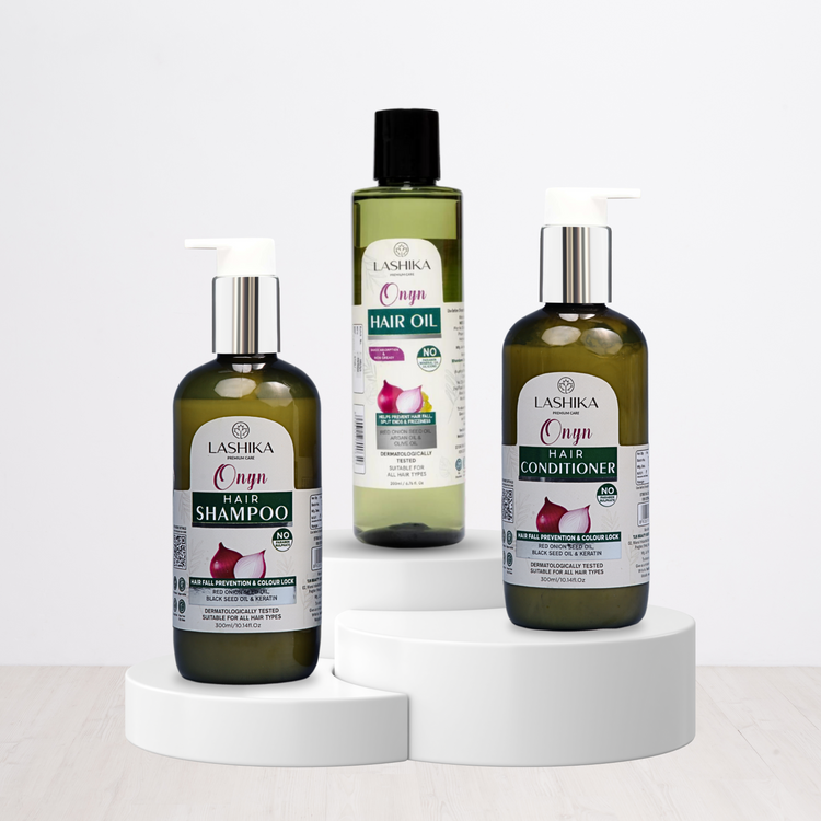 A set of three Lashika Onyn hair care products displayed on a white surface. From left to right, the products are:

Lashika Onyn Hair Shampoo: A black bottle with a white pump. The product is designed for hair fall prevention and color lock, and it is suitable for all hair types.
Lashika Onyn Hair Oil: A black bottle with a black cap. The product helps with hair fall prevention and color lock, and it is suitable for all hair types.
Lashika Onyn Hair Conditioner: A black bottle with a white pump. 